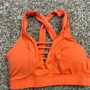 Size medium orange sports bra, born primitive.